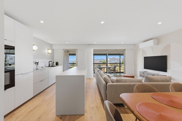 Un appartement moderne comprenant une cuisine, un coin repas et un salon.