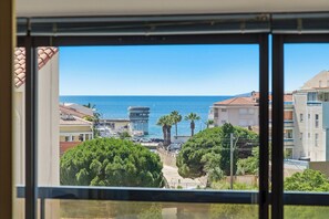 Une vue sur la côte, avec des bâtiments, un ciel dégagé et la mer.