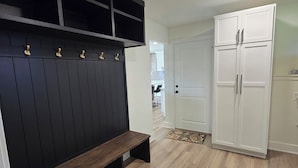 Una habitación con un banco, un armario y una puerta.