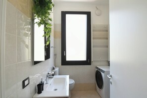 Ein Badezimmer mit Waschbecken, Toilette und Waschmaschine.