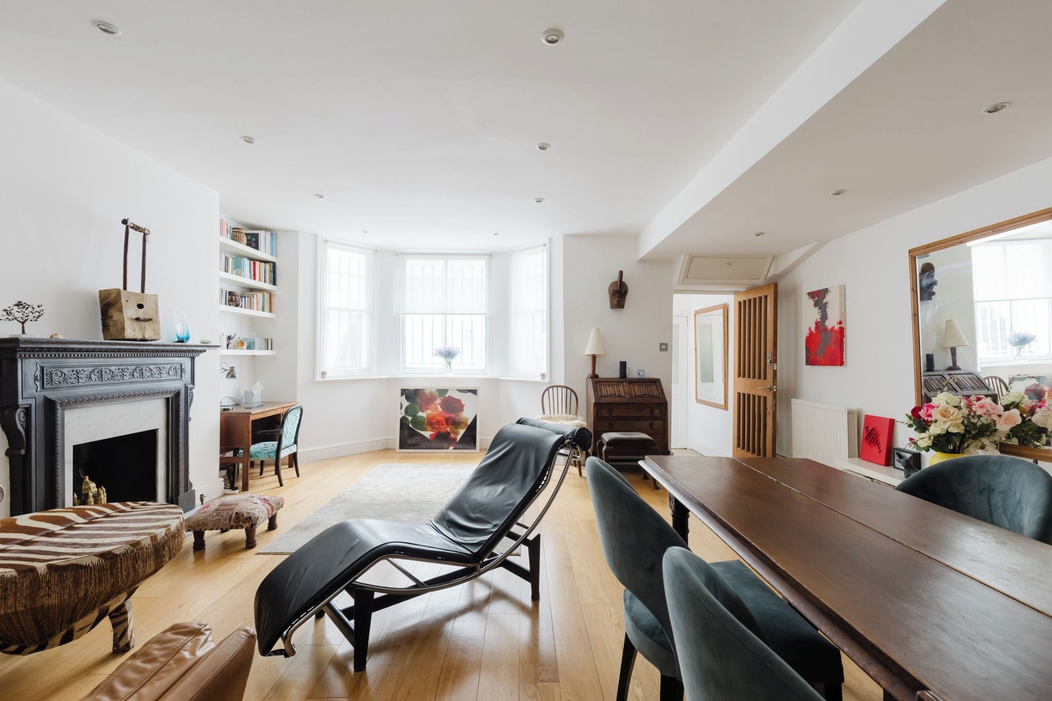 A spacious living room with a fireplace, a long dining table, and a comfortable seating area.