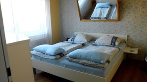 Una cama bien hecha con almohadas y una mesita de noche.