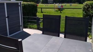 Ein überdachter Außenbereich mit Blick auf ein Sportfeld.