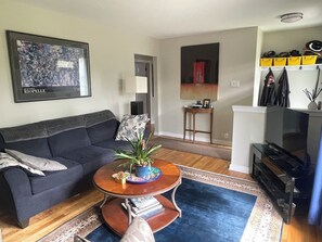 Una sala de estar con un sofá, una mesa de centro y un cuadro en la pared.