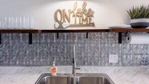 A kitchen with a double sink, a soap dispenser, a decorative sign above the sink, and a potted plant on the counter. - Incredible Lake & Mtn Views - Loft Vibes Getaway! (Tilton)