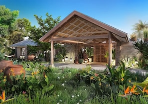 A covered outdoor area with a wooden roof, surrounded by lush greenery and potted plants.