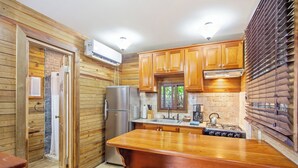 Eine Küche mit Holzausstattung, einem Edelstahlkühlschrank, einem Gasherd und einem eingebauten Backofen.