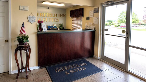 A reception desk with a sign reading 'Deerfield Inn & Suites' and a welcome sign. - Deerfield Inn & Suites Steele Near Blytheville I 55 (Steele)