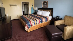 A hotel room with a bed, a desk, a chair, a telephone, and a ceiling fan. - Deerfield Inn & Suites Steele Near Blytheville I 55 (Steele)