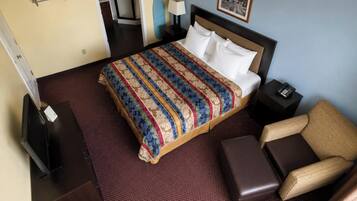Habitación de hotel con una cama grande, una silla, un escritorio y un teléfono.
