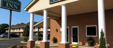 A Deerfield Inn with a brick facade, white columns, and a covered entrance.