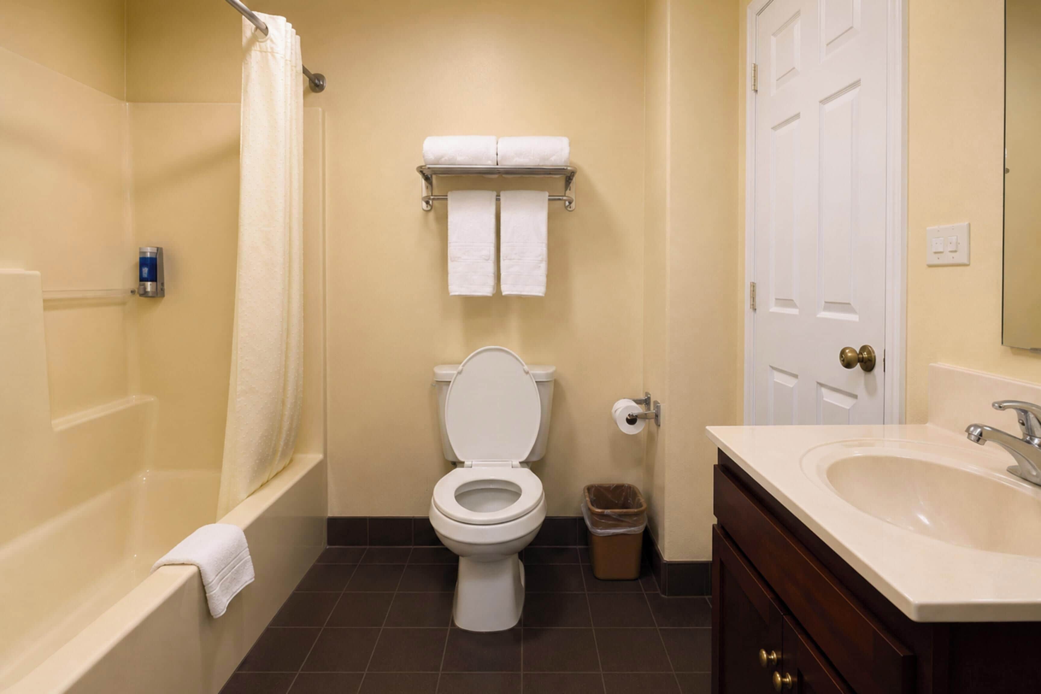 A bathroom with a toilet, a sink, a bathtub, and a shower curtain.