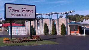 A sign for 'Town House Motor Lodge' with a parking lot and a building with a covered area. - Townhouse Motor Lodge Springfield Oh (Springfield)