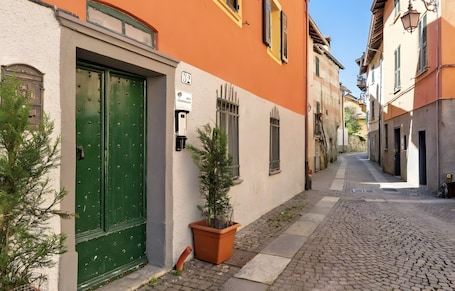 A narrow cobblestone street with buildings on either side, a green door, and a potted plant.. Apartment 'Museum View B' with Wi-Fi and Air Conditioning