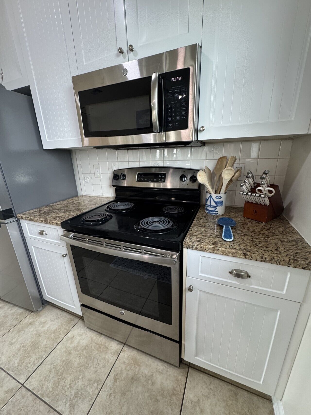 A kitchen with a stainless steel microwave, oven, and stove.