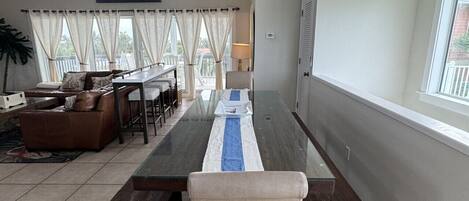 A dining area with a long table, benches, and a ceiling fan.