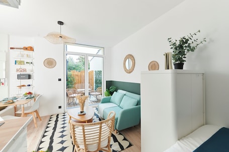 A modern living space with a dining area, a sofa, a cabinet, and a potted plant.. Studio Univers with private terrace, 2' from Lille