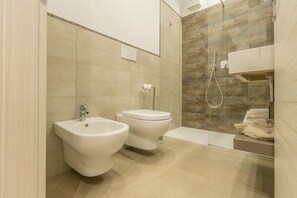 A modern bathroom with a bidet, toilet, and bathtub. - Nova Suite - Room 301 (Calatafimi)