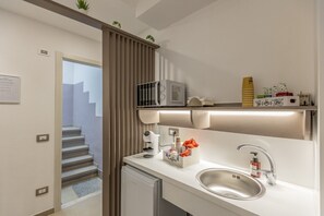 A modern kitchen with a built-in microwave, coffee station, and a stainless steel sink. - Nova Suite - Room 301 (Calatafimi)