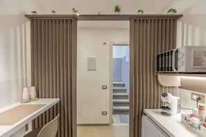 Une chambre d’hôtel équipée d’une kitchenette, d’un four à micro-ondes, d’un coin café et donnant sur l’escalier.