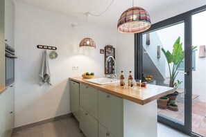 Een keuken met een houten aanrecht, een spoelbak, handdoeken en een plant in pot.