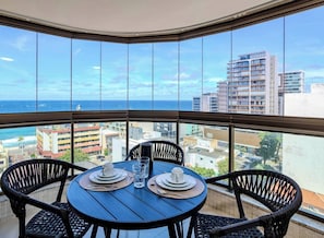 Ein Eckbalkon mit Tisch für zwei Personen, mit Blick auf die Stadt und das Meer.