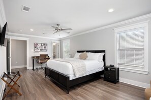 A bedroom with a bed, bedside table, and a ceiling fan. - Garden District Luxury Oasis-Private Garage (Baton Rouge)