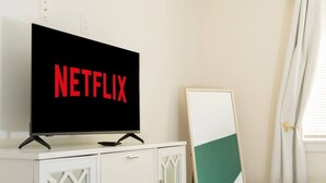 En tv-apparat med Netflix-logotypen på ett vitt skåp.