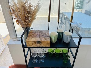 Uma prateleira com uma caixa decorativa, três canecas e quatro copos.