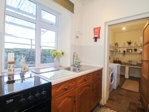 A kitchen with a stove, sink, and wooden cabinets. - Beach Farmhouse (Bishops Castle)