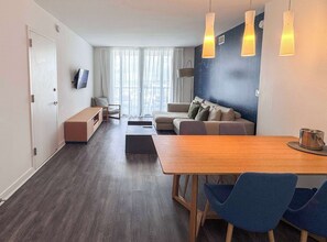 Ein modernes Wohnzimmer mit einer Couch, einem Couchtisch und einem an der Wand montierten Fernseher.