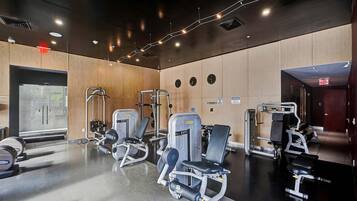 Un gimnasio con equipo de ejercicio, paredes de madera y un espejo grande.
