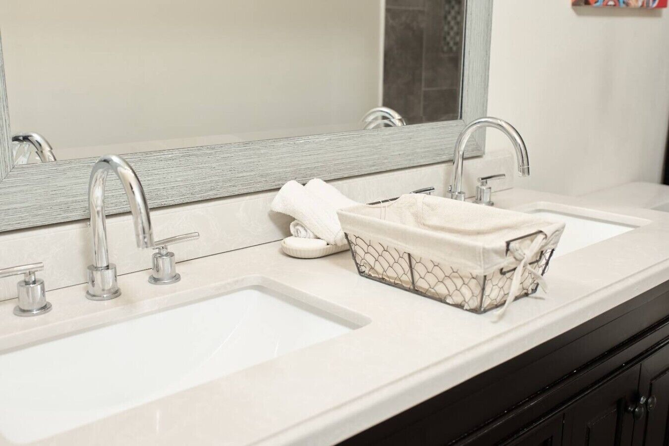 A bathroom with two sinks, a large mirror, and a towel rack.