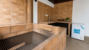 Una cocina con una parrilla integrada, un fregadero y un refrigerador.
