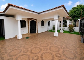 A building with a tiled roof, white walls, and a patterned floor.