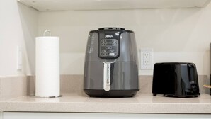 A kitchen with a coffee maker, a toaster, and a paper towel dispenser. - Lux, First Floor, Fast-WiFi King Size (McAllen)