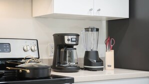 A kitchen with a stove, coffee maker, blender, and a cabinet. - Lux, First Floor, Fast-WiFi King Size (McAllen)