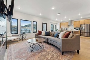 Un salon moderne avec un canapé, une table basse et de grandes fenêtres.