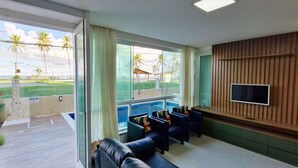 A room with a pool view, a TV, and a seating area. - COSTE0114 - Inba Stella Residence (Salvador)