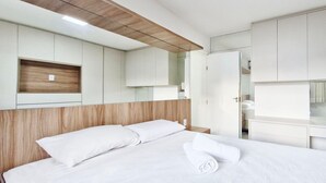 A modern hotel room with a bed, built-in wardrobe, and a wooden headboard. - COSTE0114 - Inba Stella Residence (Salvador)