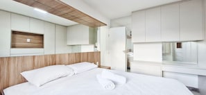 A modern hotel room with a bed, built-in wardrobe, and a wooden headboard. - COSTE0114 - Inba Stella Residence (Salvador)