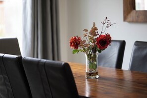 Et spisebord med en klar glasvase med blomster.