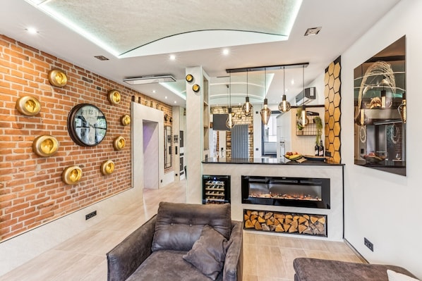 Ein modernes Wohnzimmer mit Backsteinwand, Kamin und Sofa.