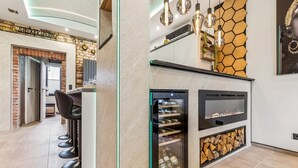 Eine moderne Küche mit Weinkühlschrank, eingebautem Ofen und einer Wandgestaltung mit sechseckigen Elementen.