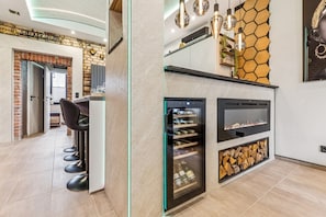 Eine moderne Küche mit Weinkühlschrank, eingebautem Ofen und einer Wandgestaltung mit sechseckigen Elementen.