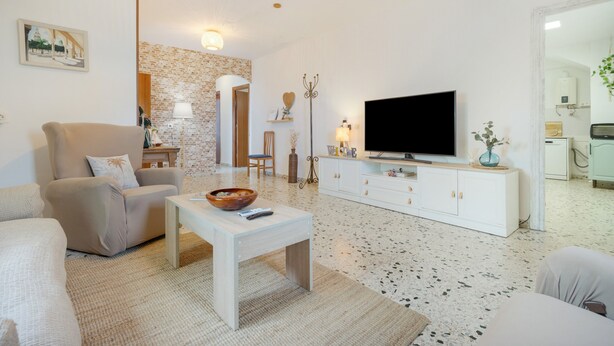 Un salon moderne avec un canapé, une table basse, un téléviseur et une cheminée.