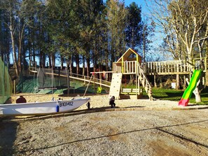 A playground with a wooden climbing structure, a slide, and a boat with the number B10142. - In Nature – Spa – 2km from City Center (Quimper)