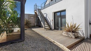 A modern building with a wooden deck, a staircase, and a glass door. - In Nature – Spa – 2km from City Center (Quimper)