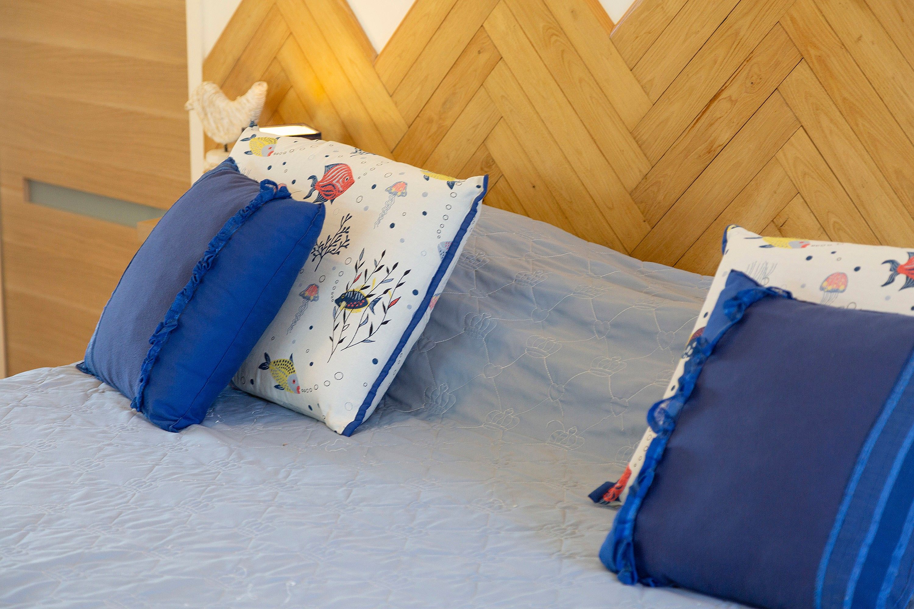 A bed with a wooden headboard and decorative pillows.