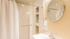 A bathroom with a shower, a sink, a mirror, and a towel rack. - The Master Suite / King Size Bed /Walk in Shower (McAllen)
